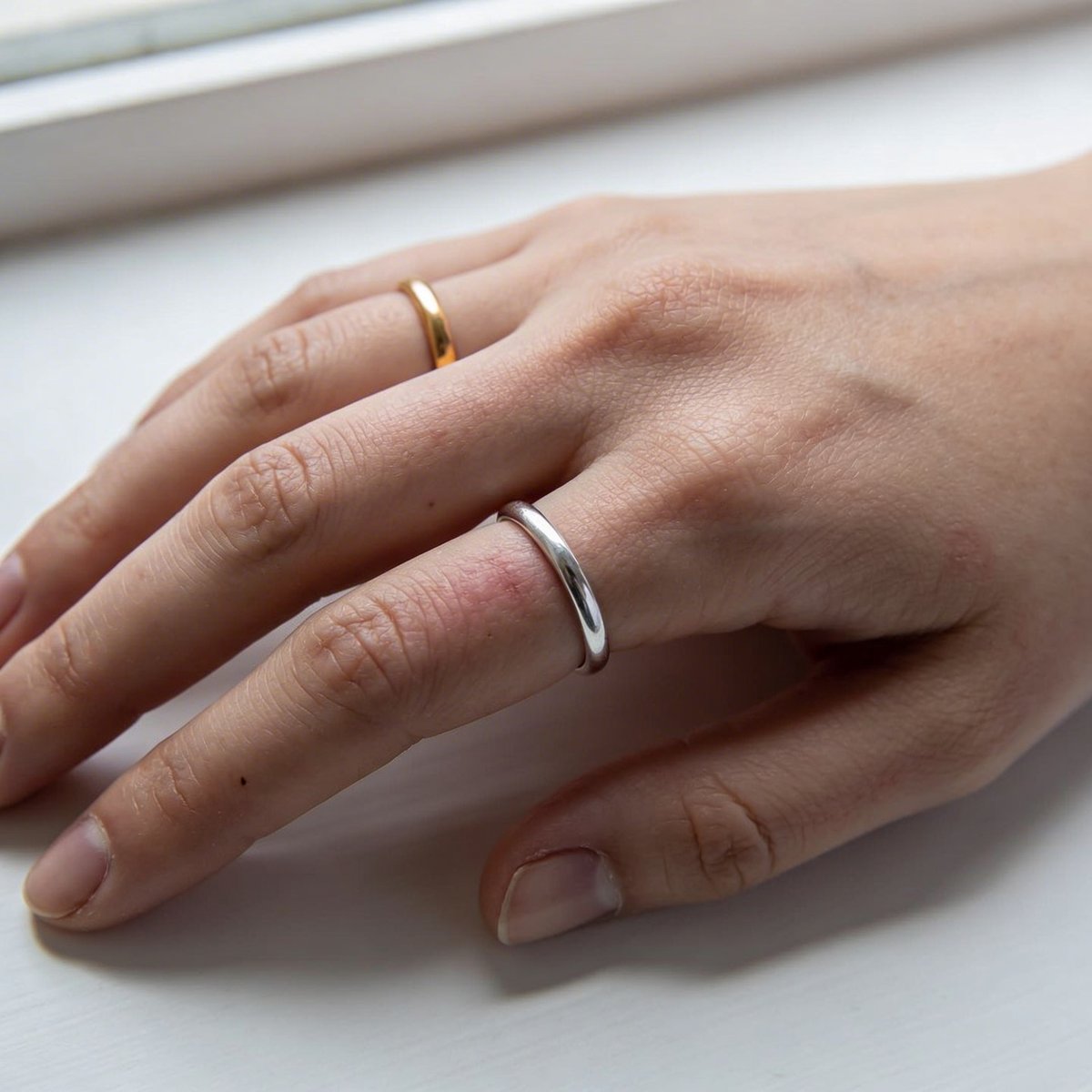 Goud vs zilver test: gouden en zilveren sieraden naast elkaar op de huid om de ondertoon te bepalen